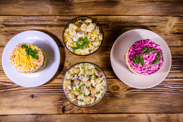 Set of festive mayonnaise salads on wooden table. Top view