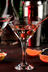 Martini. Alcoholic drink martini with olives in a glass on a dark background in the bar on the bar counter. bar inventory. cocktails