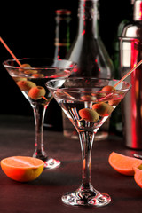 Martini. Alcoholic drink martini with olives in a glass on a dark background in the bar on the bar counter. bar inventory. cocktails