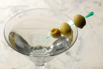 Martini. Alcoholic drink martini with olives in a glass on a light background in the bar on the bar counter. bar inventory. cocktails