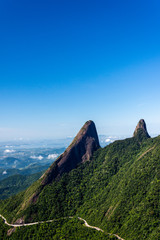 Postcard trail view where you can observe in detail de vegetation and topography of the to Serra dos Orgãos (Organs Mountain) with Finger's God highlighted in landscape.