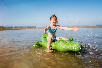 belle jeune fille jouant avec son crocodile gonflable