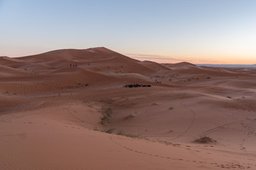 Gorgeous and scenic desert scene with the moon crescent high above beautiful sand dunes Erg Chebbi, Morocco, Merzouga