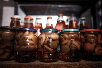 Glass jars filled with apple fruits and juice in the cellar
