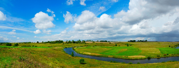 Beautiful panoramic landscape with river and green fields