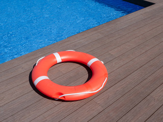 red life buoy on the edge of a swimming pool