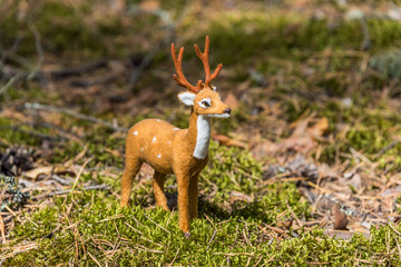 Little Toy Deer in a Green Forest on a Sunny Day