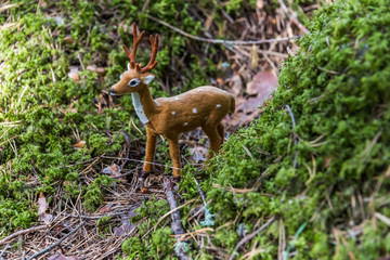 Little Toy Deer in a Green Forest on a Sunny Day
