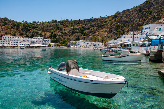 Small boats in the picturesque harbour of Loutro on the Greek island of Crete with turquoise waters and white washed buildings