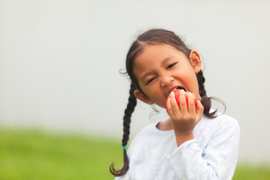 Happy Girl eating apples on kitchen