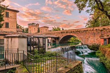view of Bevagna, Umbria, Italy, with bridge, canal of the old mills and waterfalls