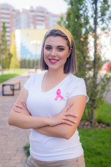 Portrait of young girl with  pink ribbon, symbol of cancer. Breast cancer awareness month.Strong woman fights cancer.