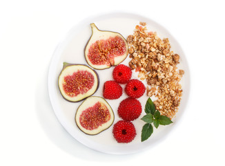 Yoghurt with raspberry, granola and figs in white plate isolated on white background. top view.