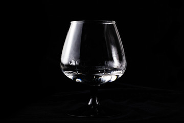 Cognac glass with sambuca on a black background alone