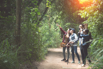 Obraz premium Friends or tourists with colorful backpacks in forest. Summer vacation. Travelling, hiking