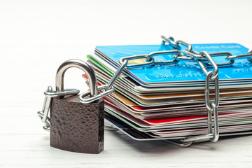 Stack of credit cards and a padlock with chain isolated on a white background. Closed access to...