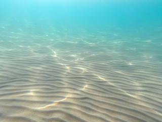 Clear water. underwater background with sandy sea bottom. Beautiful texture of the sea and ocean...