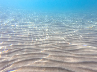 Clear water. underwater background with sandy sea bottom. Beautiful texture of the sea and ocean...