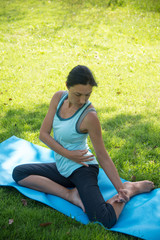 Healthy middle aged woman doing yoga in the park