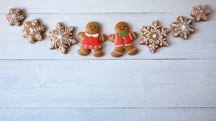Christmas gingerbread cookies, snowflakes, gingerbread men on a wooden background