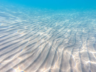 Clear water. underwater background with sandy sea bottom. Beautiful texture of the sea and ocean water.