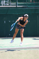 サーブを打つ女子テニスプレイヤー