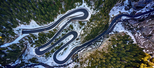 Aerial drone view of a serpentine in rocky mountain forest, Bicaz gorge with winding road in winter season,Cheile Bicazului, Romania