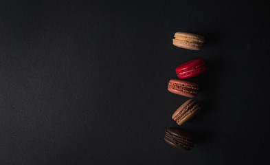 Colourful macaroons on a black colour background,Food concept background Top view Design 