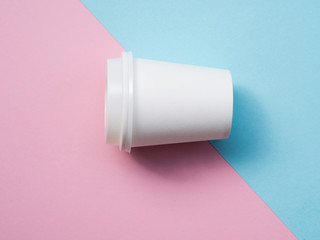 Top view small paper coffee cup isolated on a pink and blue pop background. White espresso cup mockup