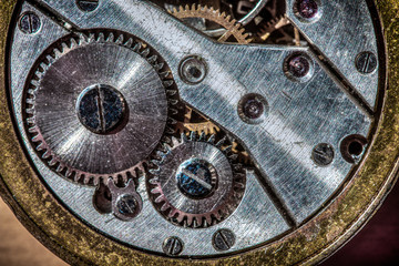 Detail of an antique watch with cogwheels gold and silver colored
