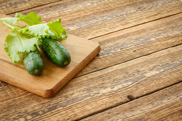 Just picked cucumbers and leaves of salad lying on cutting board.