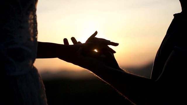 Close up of in love guy putting engagement ring to his loved girlfriend at sunset. Valentines day. Getting engaged.