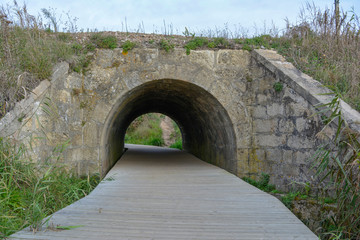 Wooden footbridge through the stone tunnel