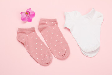 Two pairs of women socks on pink background.
