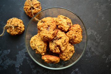 Oatmeal cookies with chocolate. Cookies on a black table background, isolated. A stack of cookies with cords.