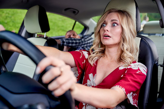 Image Of Surprised Female Driver Driving, Male Passenger In Car