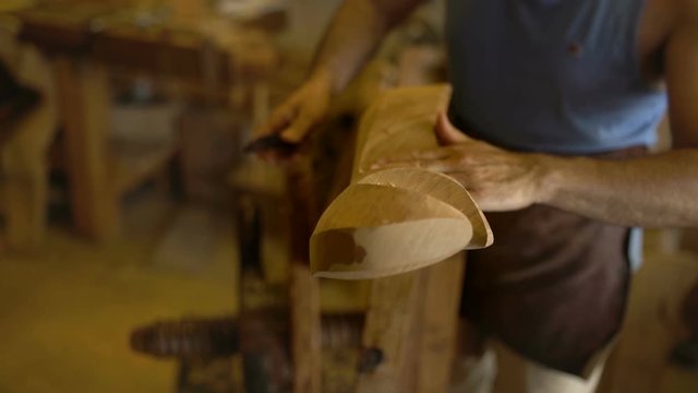 Closeup on hands of an old craftsman making a historic forcola, a wooden oarlock for gondolas, the traditional boats in Venice, Venezia. 