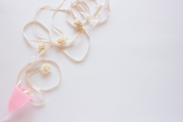 Menstrual cup with flowers on white background. Close up, flatlay