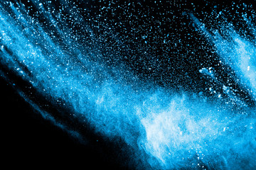 Blue color powder explosion on black background.