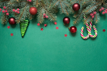 Christmas tree branches, red glass balls on green with copy space. Top view. Holiday Xmas card.