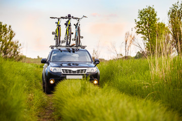Black crossover with three bicycles on roof rack