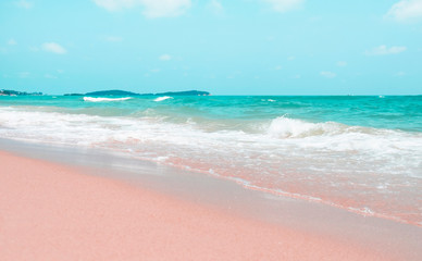 Fototapeta na wymiar Pink and blue colours, waves on the sand beach