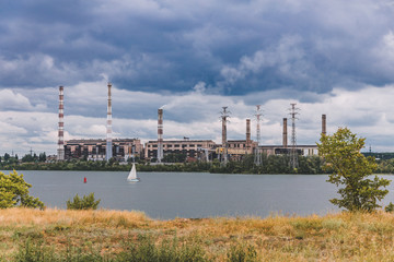 Obraz premium nuclear power plant near the river with a yacht
