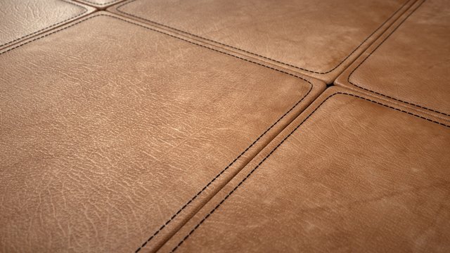 Leatherwork, detail of stitched brown leather tiles.