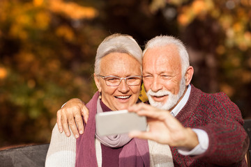 Couple of modern grandparent taking selfie