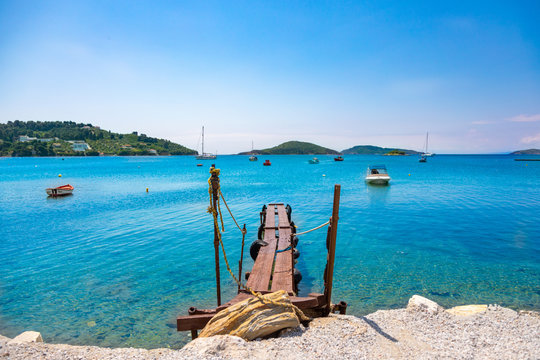 Old wooden dock reaching out in the blue waters of Skiathos