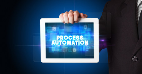 Young business person working on tablet and shows the inscription: PROCESS AUTOMATION