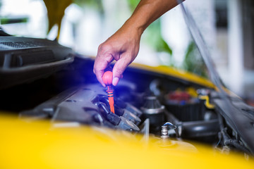 Check the oil level in yellow car engine. Mechanic checking car engine or vehicle. Check and maintenance car with yourself.