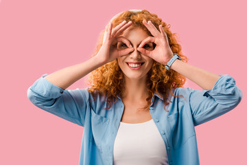 smiling girl making glasses from hands, Isolated On pink