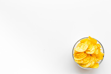 Junk food concept with heap of potato crisps on white background top view space for text